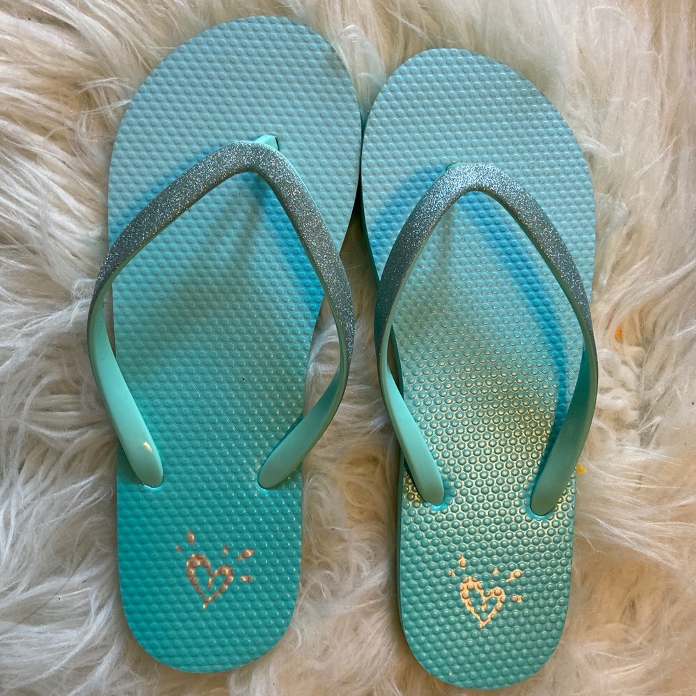 Flip flops that are blue with glitter and grips